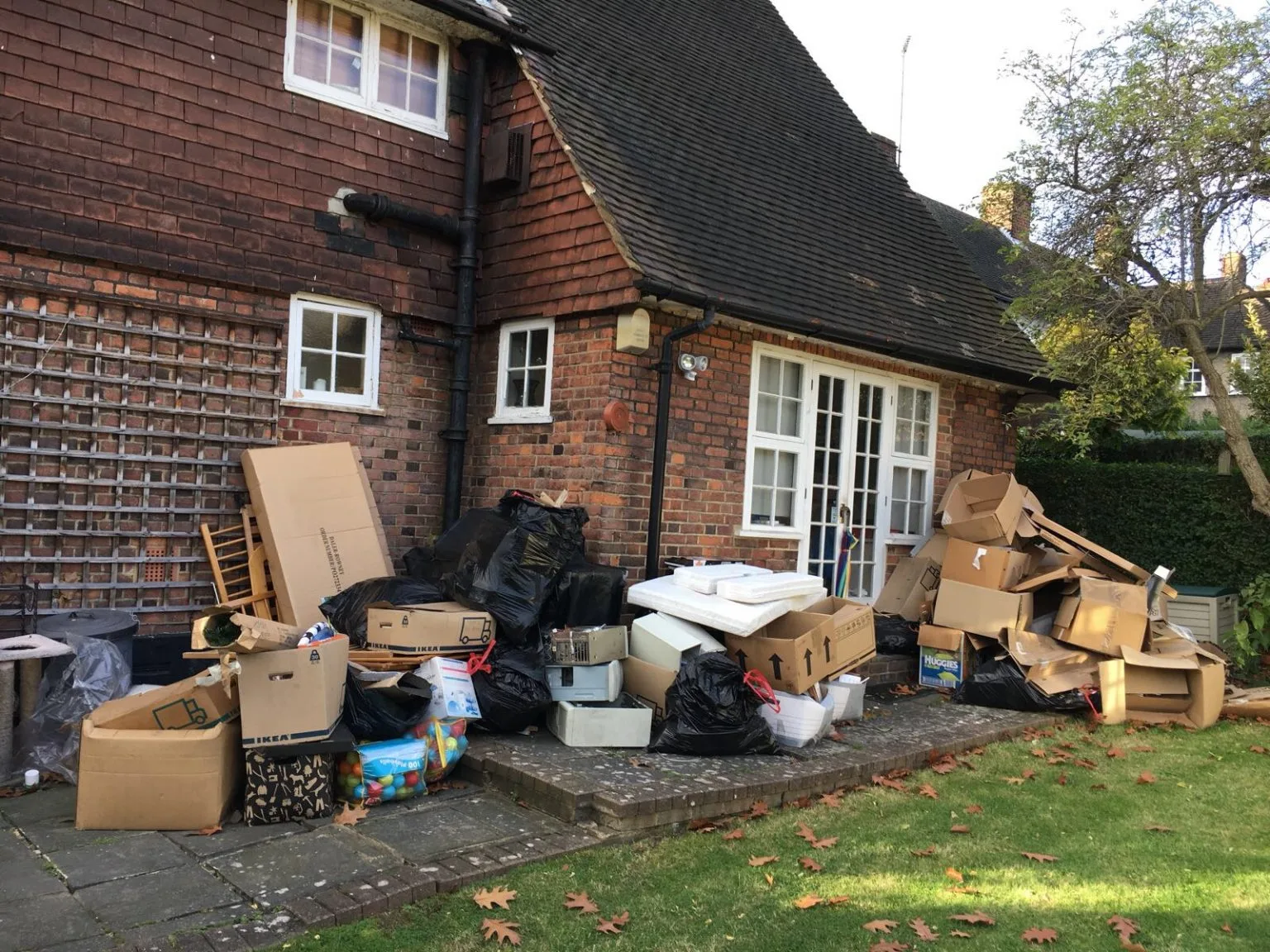 Boxes, bags and old furniture stacked outside a West London house ready for an MV Movers clearance